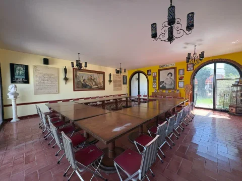 Salón comedor con mesa larga y arcos hacia el jardín