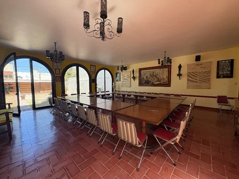 Salón comedor con mesa para grupos y ventanales en arco