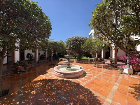 Patio central con fuente, rodeado de árboles y corredores