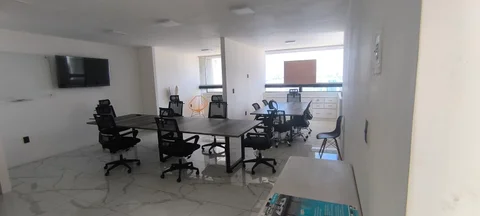 Área de trabajo con mesas de juntas, sillas y pantalla