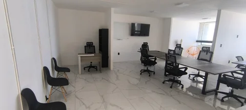 Vista amplia de la oficina con recepción y mesas de trabajo